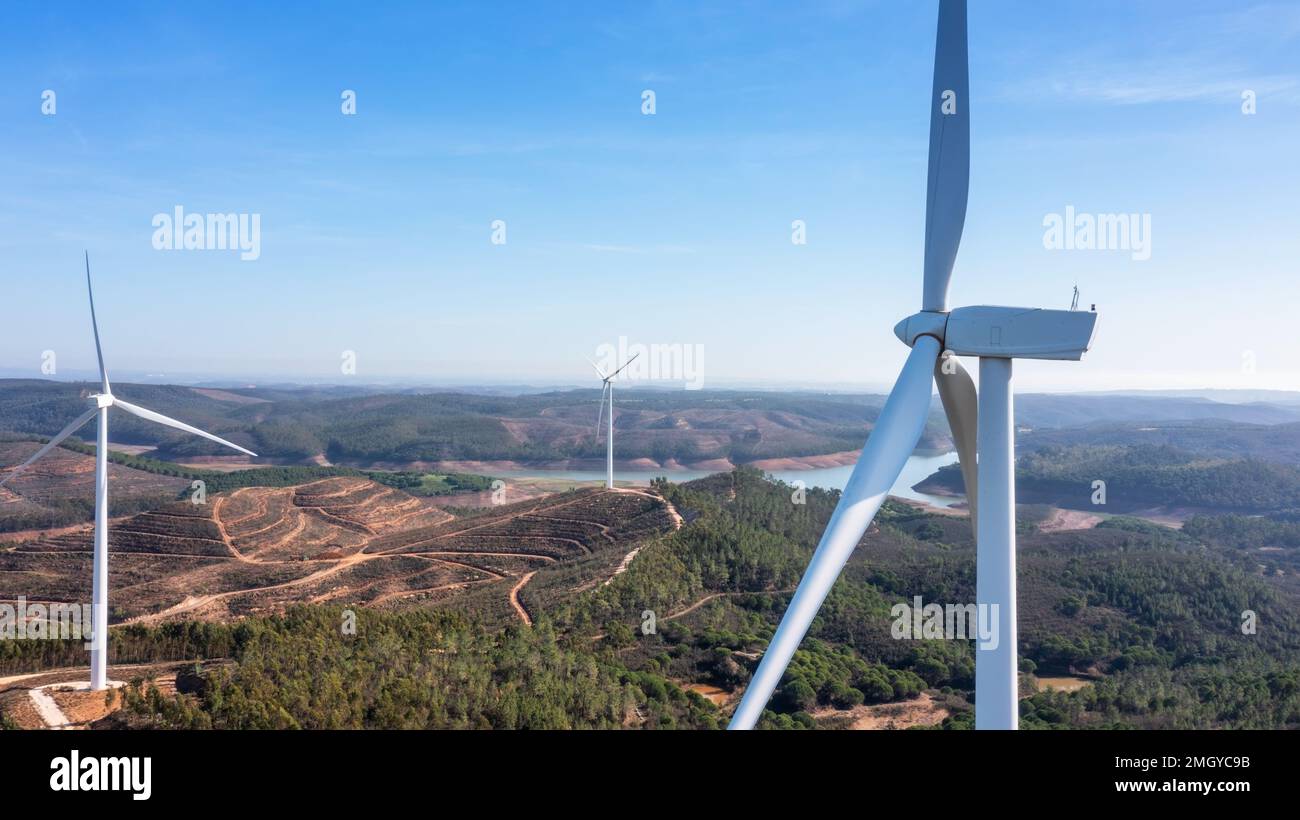 Le turbine eoliche generano elettricità pulita e verde nei campi del Portogallo. Con vista sulla diga di Bravura. Foto Stock