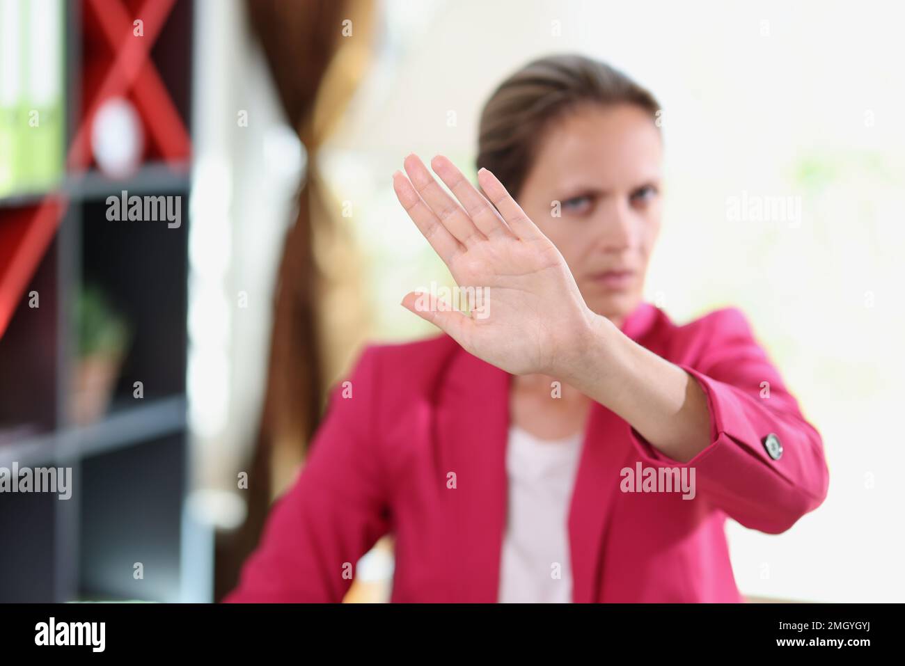 Donna manager serio che mostra un gesto di disaccordo mentre si siede in ufficio. Foto Stock