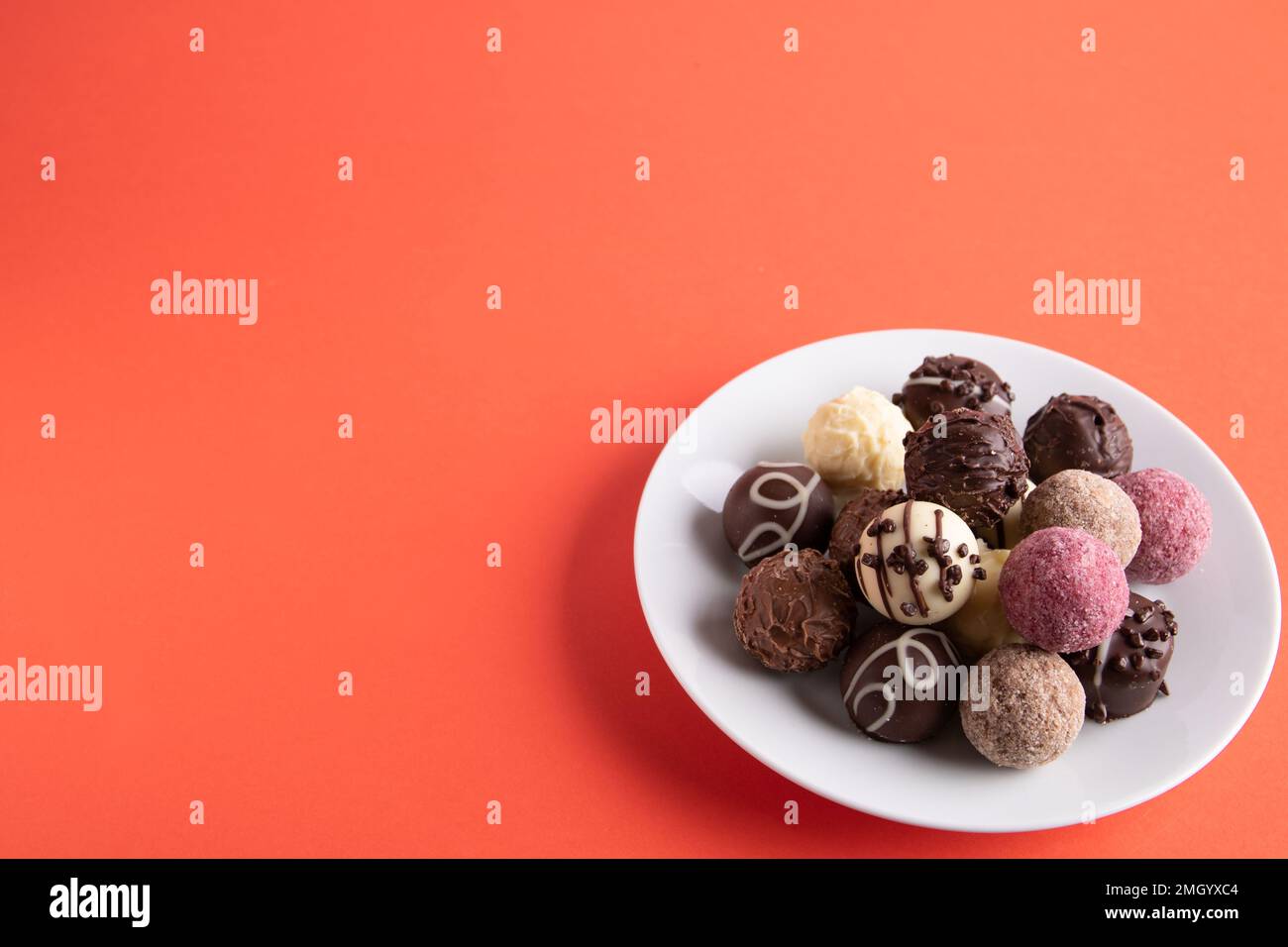 fotografa un sacco di dolci al cioccolato su un piatto bianco Foto Stock