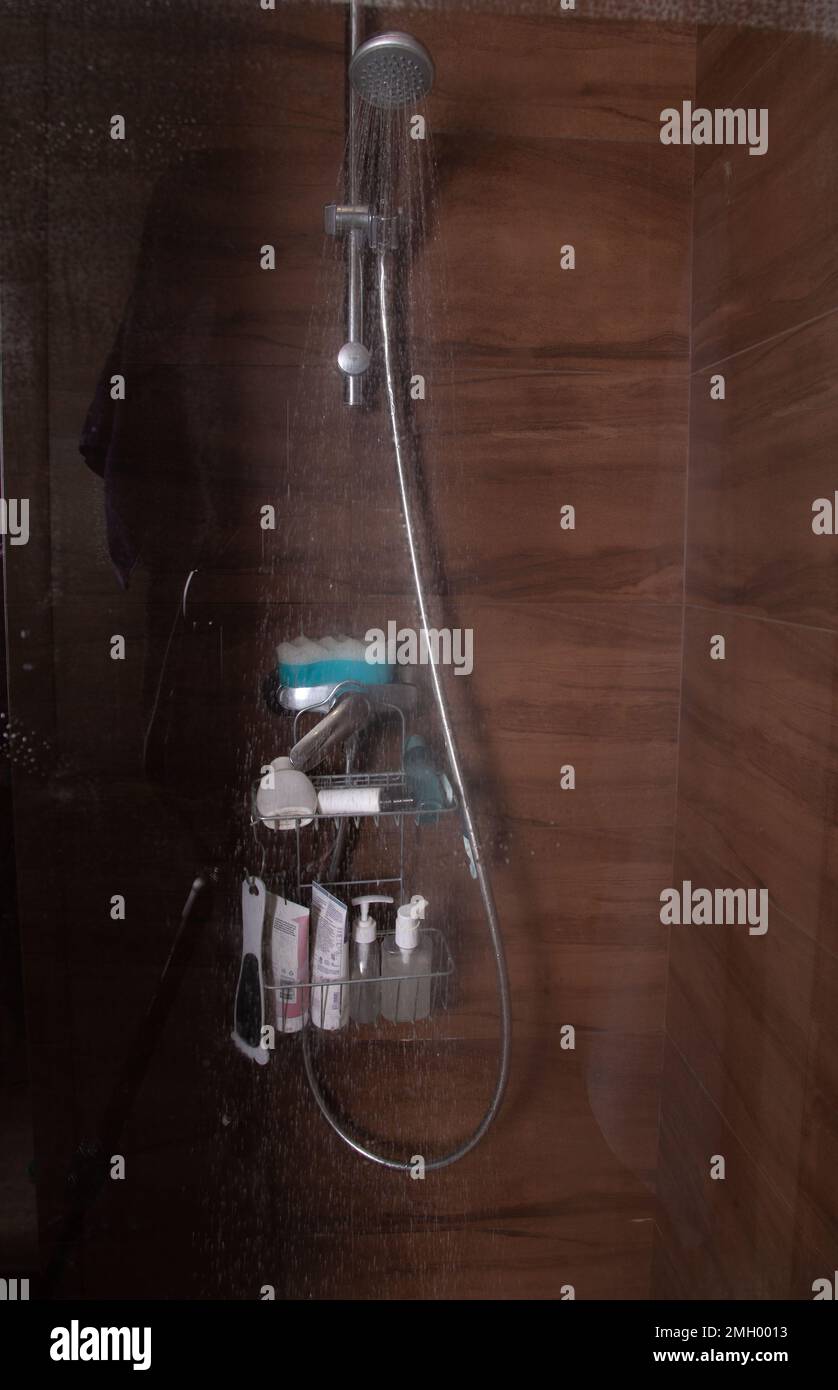 foto di una doccia attivata che si versa in un box doccia Foto Stock