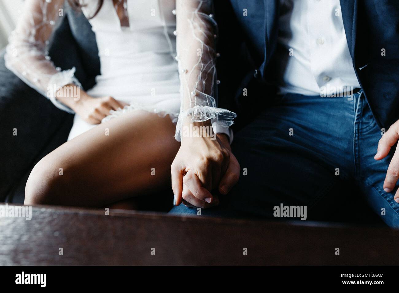 Coppia di nozze innamorata che tiene le mani sul loro giorno di nozze Foto Stock