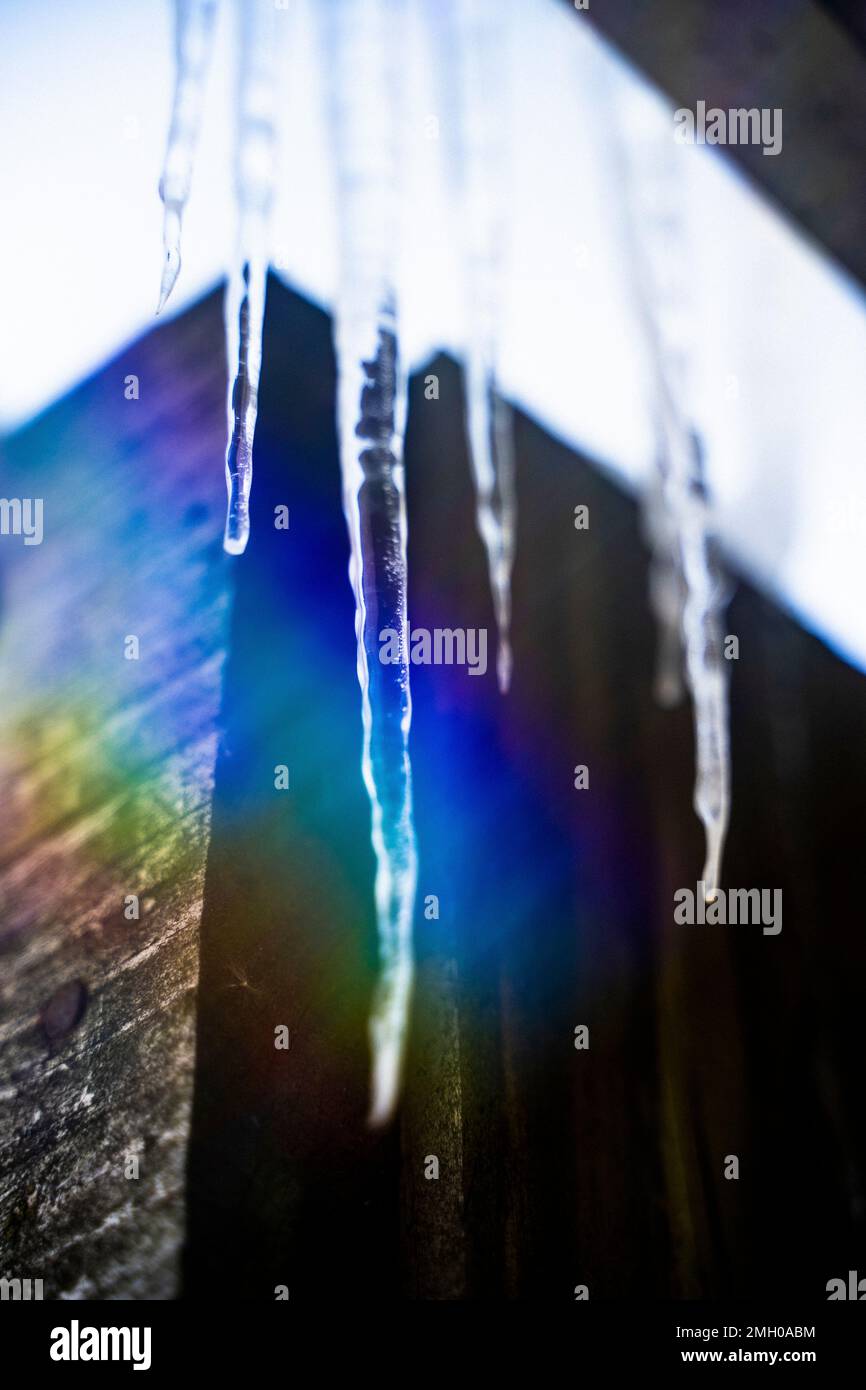 Icicles on Roof Melting in Rainbow Light realizzato da Prism in inverno Foto Stock