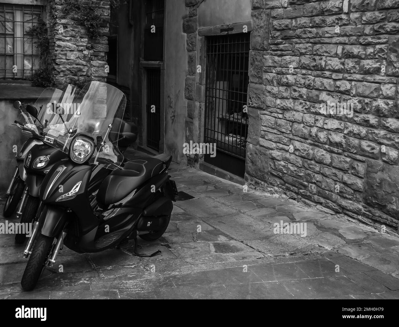 Moto moderne su strada vecchia, foto in bianco e nero, Bergamo, Italia Foto Stock