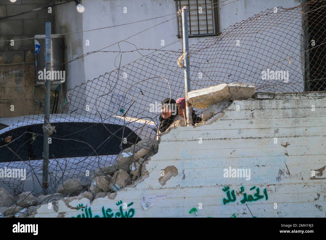 I palestinesi ispezionano i resti di strutture e veicoli distrutti, danneggiati da un bulldozer militare israeliano durante lo storming della città di Jenin nella Cisgiordania occupata. Le grandi forze dell'esercito israeliano hanno colpito la città di Jenin e hanno ucciso dieci palestinesi, tra cui una donna, e ferito più di venti altri con proiettili vivi durante gli scontri tra loro e le forze che li hanno confrontati. L'esercito ha detto che l'incursione era su un appartamento della cella nel campo profughi di Jenin, che ha avuto inizio dopo 'informazioni di intelligence accurate' fornite dal servizio di sicurezza. L'esercito e fo Foto Stock