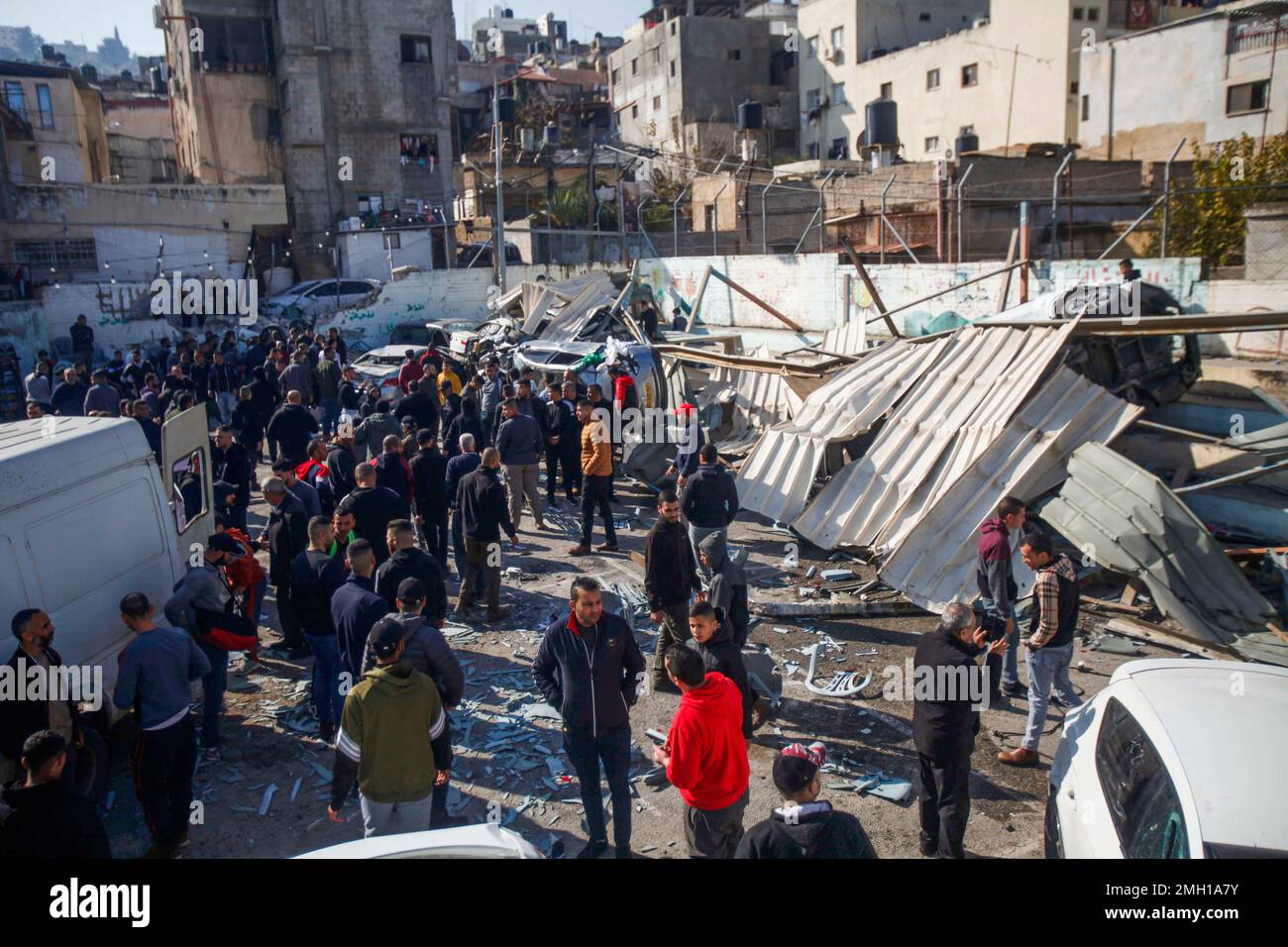 I palestinesi ispezionano i resti di strutture e veicoli distrutti, danneggiati da un bulldozer militare israeliano durante lo storming della città di Jenin nella Cisgiordania occupata. Le grandi forze dell'esercito israeliano hanno colpito la città di Jenin e hanno ucciso dieci palestinesi, tra cui una donna, e ferito più di venti altri con proiettili vivi durante gli scontri tra loro e le forze che li hanno confrontati. L'esercito ha detto che l'incursione era su un appartamento della cella nel campo profughi di Jenin, che ha avuto inizio dopo 'informazioni di intelligence accurate' fornite dal servizio di sicurezza. L'esercito e fo Foto Stock