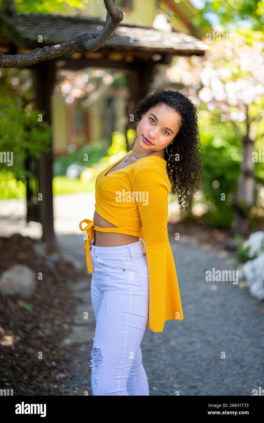 Vista laterale 3/4 Body Portrait of Happy Young African American Woman Standing with Behind Body and Head Tilted Backwards - Spring - Springtime Foto Stock