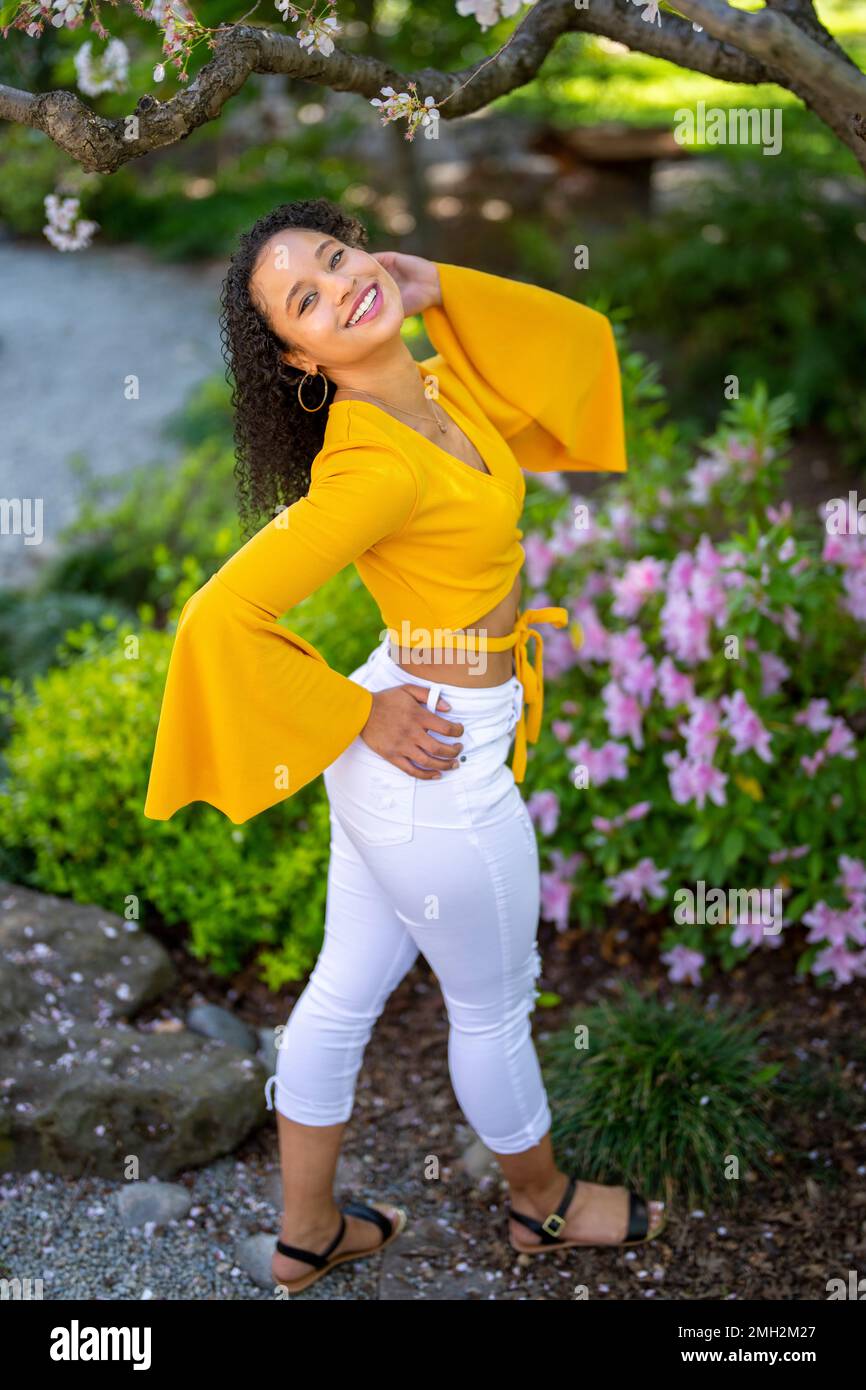 Down Angle Portrait of Happy Young African American Woman in a fioritura Japanese Style Garden a Springtime - Spring Foto Stock