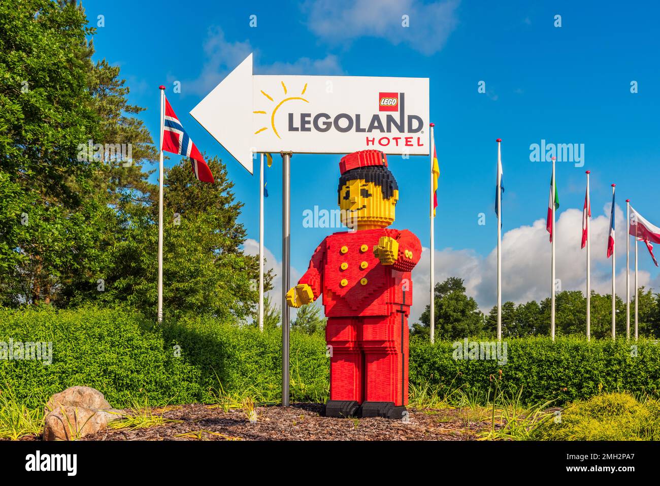 Cartello direzionale per Legoland Hotel a Billund, Danimarca, accompagnato da una gigantesca figura Lego Minifigure Foto Stock