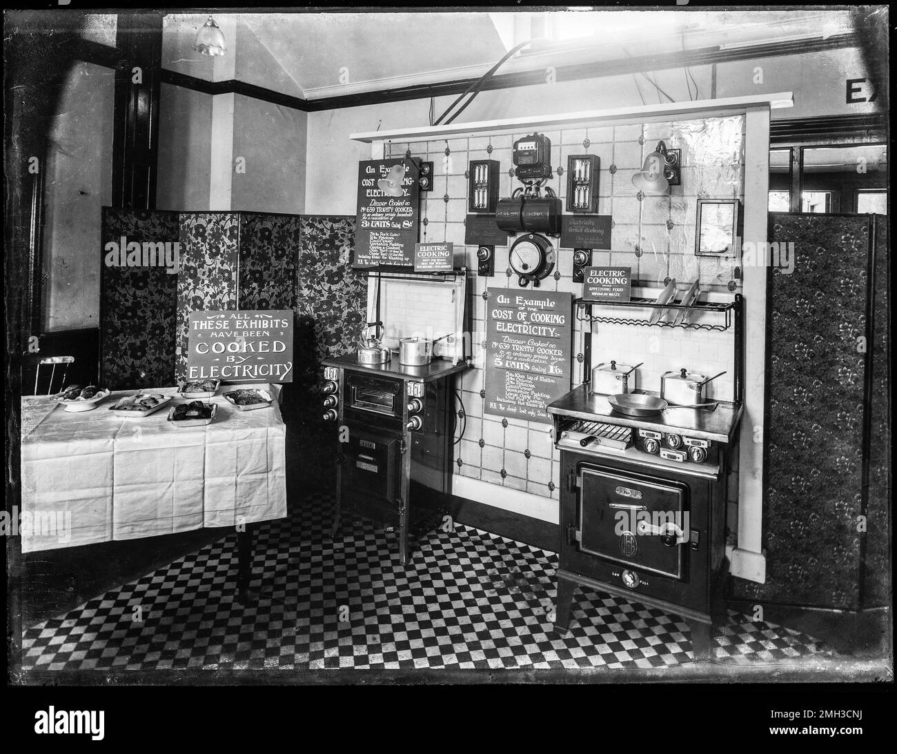Storico cucinato da Elettricità mostra dei benefici di cucinare da elettricità. Si crede di essere stato al British Empire Exhibition 1924. Archivio fotografico in bianco e nero da vetro originale pieno negativo. Foto Stock