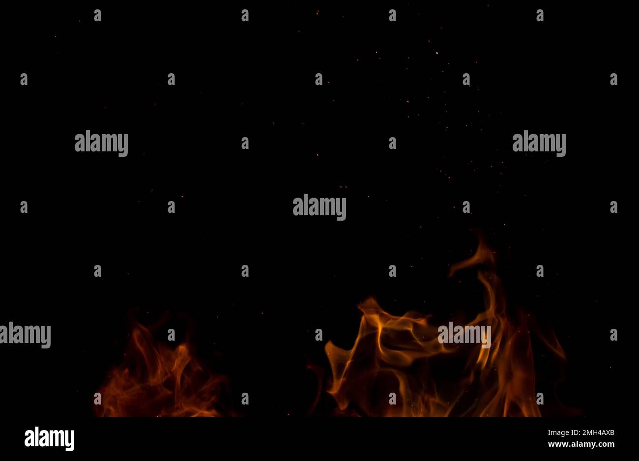 Scintille da una fiamma in movimento su sfondo nero. Astrazione di fiamma sfocata. Foto Stock