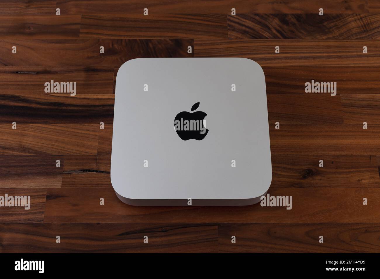 LONDRA - 24 GENNAIO 2023: Mini computer Apple Mac con logo vista dall'alto su sfondo in legno da ufficio Foto Stock