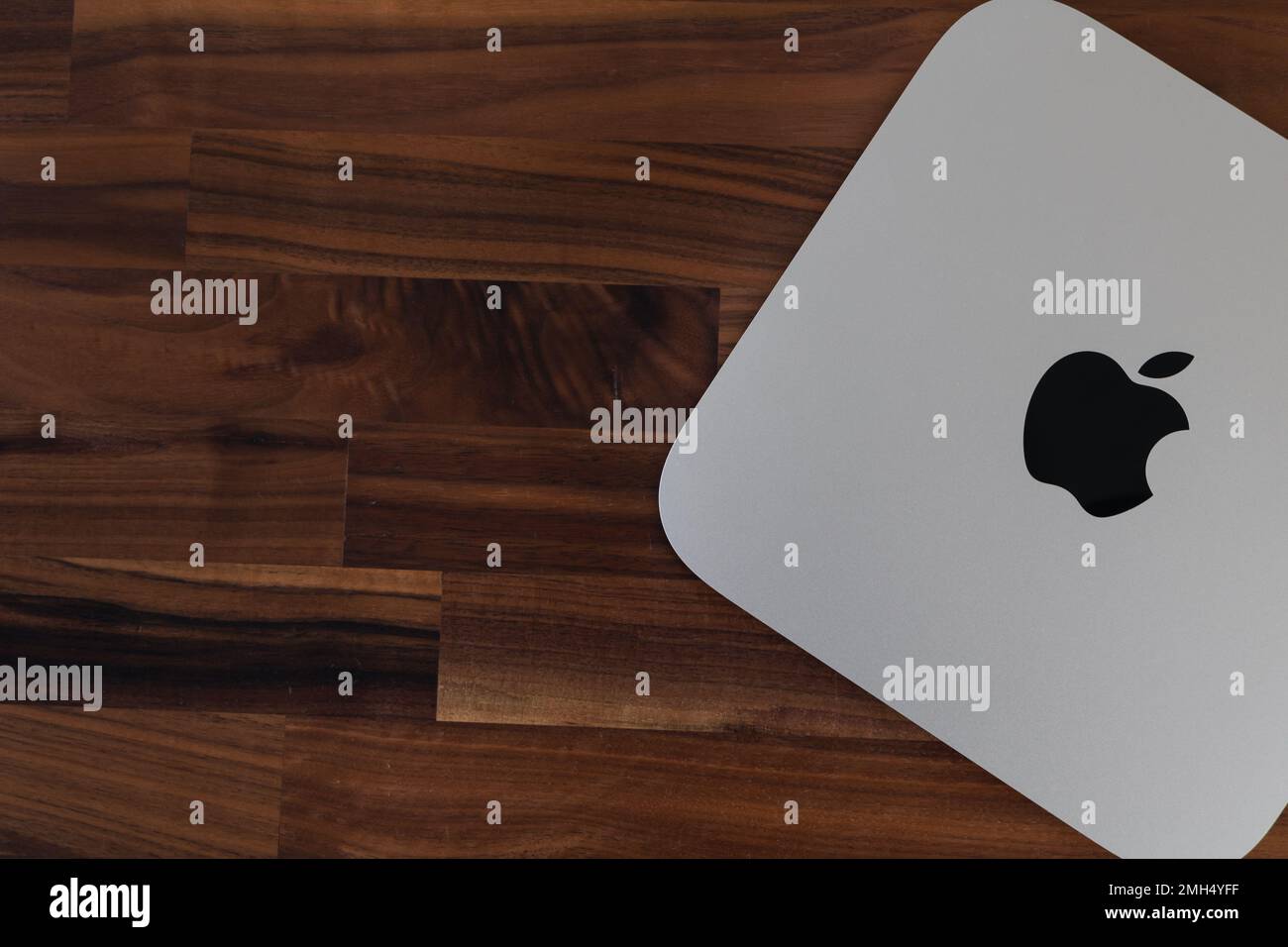 LONDRA - 24 GENNAIO 2023: Mini computer Apple Mac con logo vista dall'alto su sfondo in legno da ufficio Foto Stock