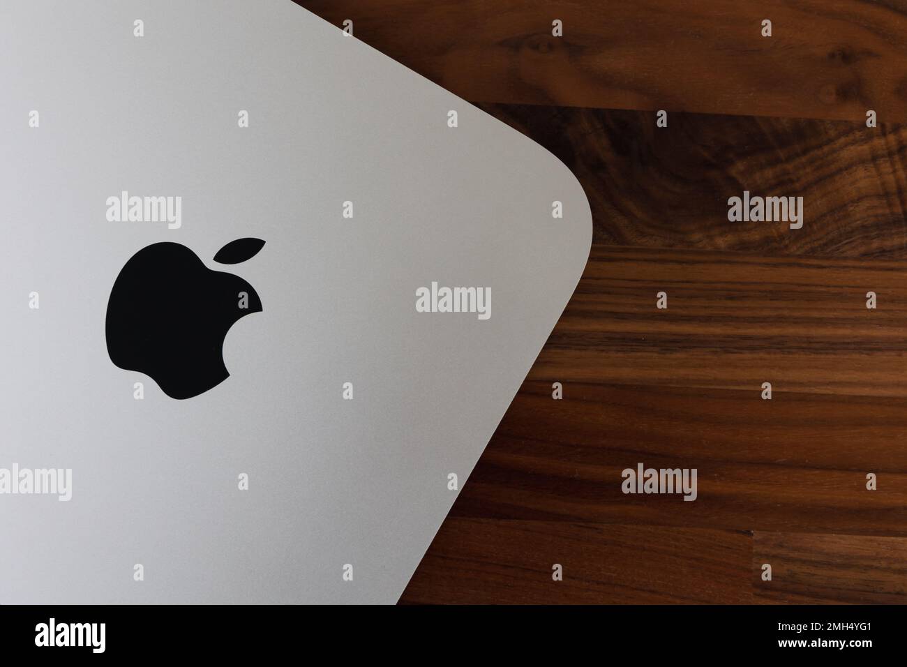 LONDRA - 24 GENNAIO 2023: Mini computer Apple Mac con logo vista dall'alto su sfondo in legno da ufficio Foto Stock