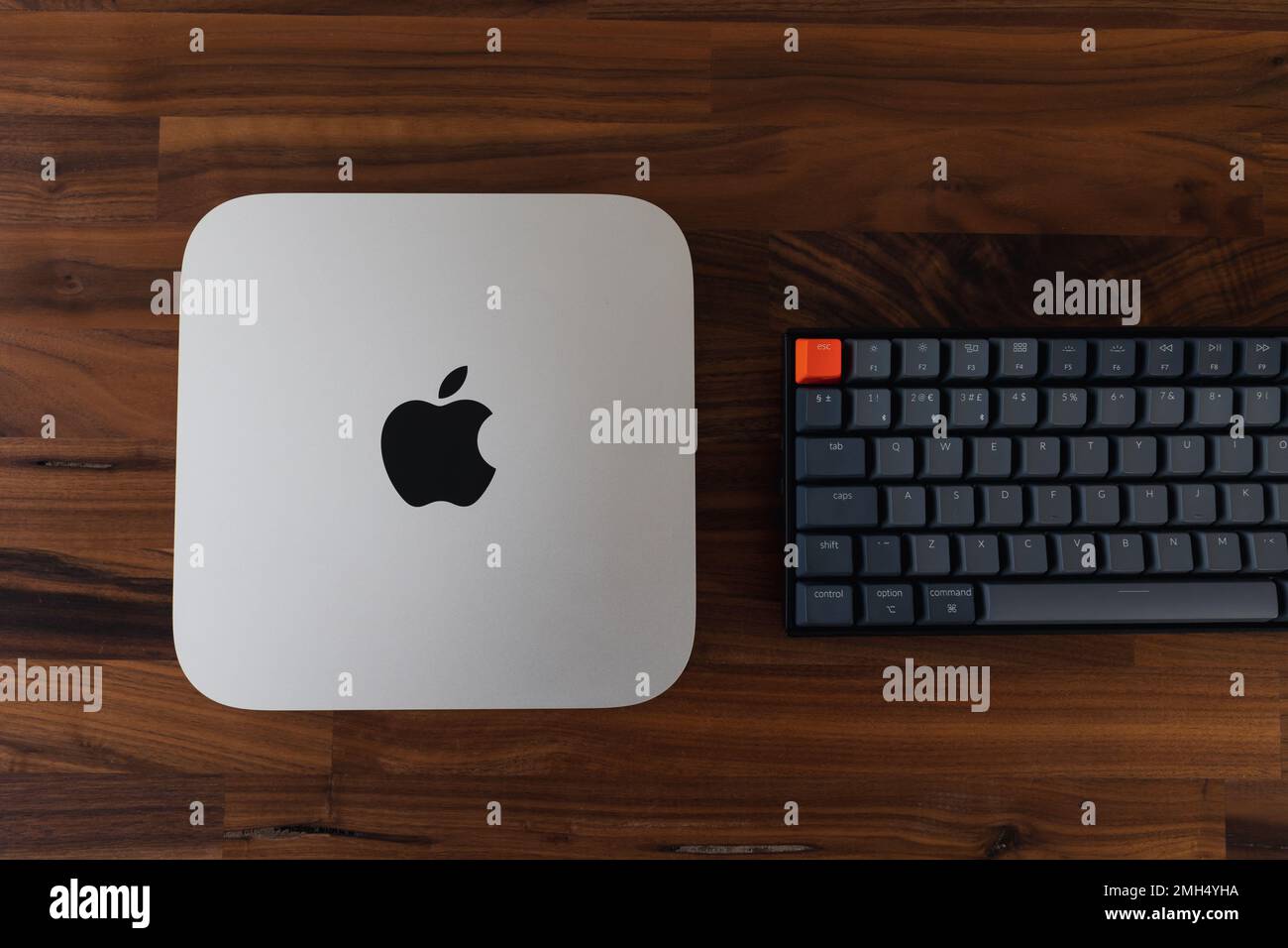 LONDRA - 24 GENNAIO 2023: Mini computer Apple Mac con logo vista dall'alto su sfondo in legno da ufficio Foto Stock