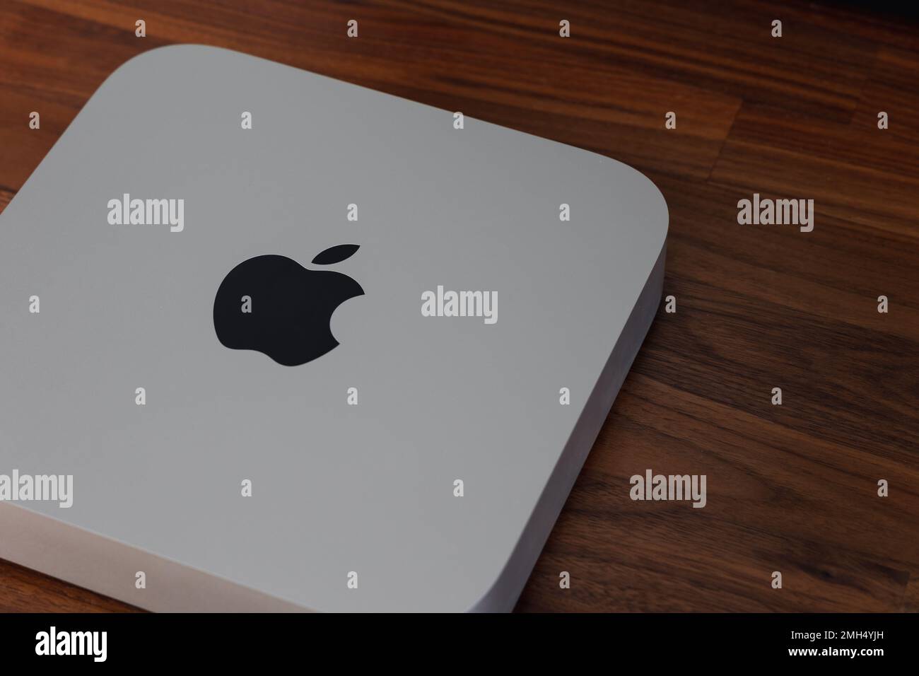 LONDRA - 24 GENNAIO 2023: Mini computer Apple Mac con logo vista dall'alto su sfondo in legno da ufficio Foto Stock