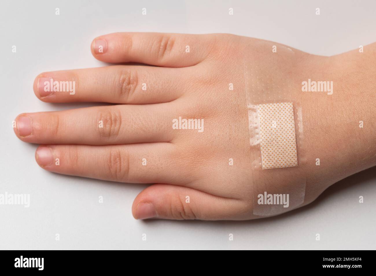 Cerotto adesivo adesivo sulla mano del bambino vista ravvicinata isolata Foto Stock