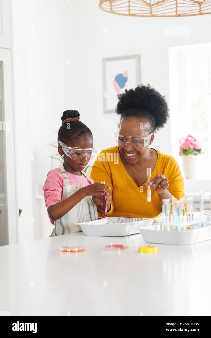 Felice afroamericana nonna e nipote che fanno esperimenti di chimica in cucina Foto Stock