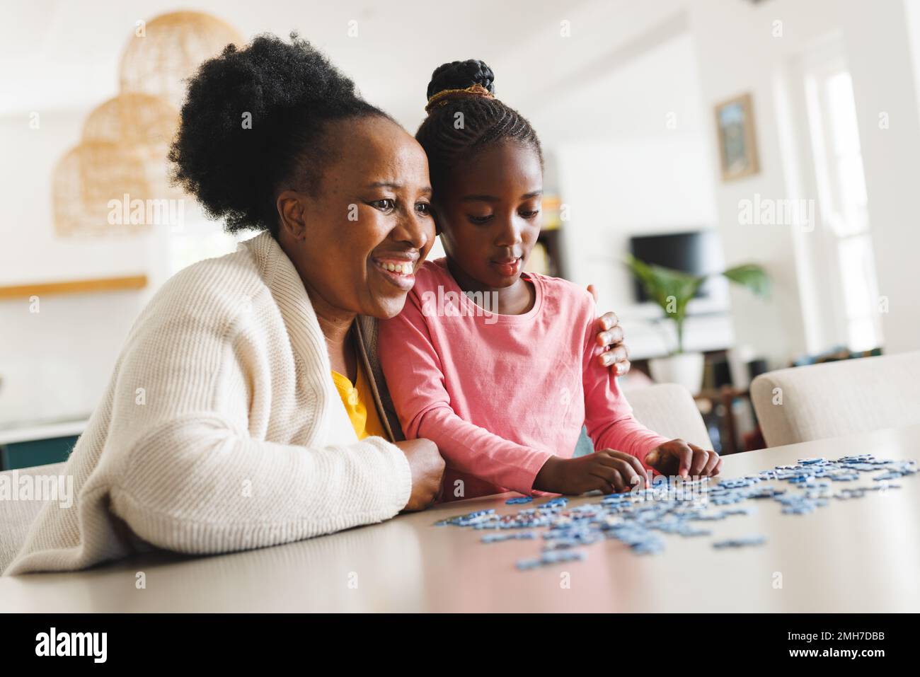 Felice afroamericana nonna e nipote fare puzzle Foto Stock