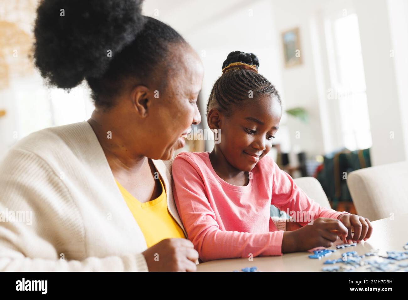 Felice afroamericana nonna e nipote fare puzzle Foto Stock