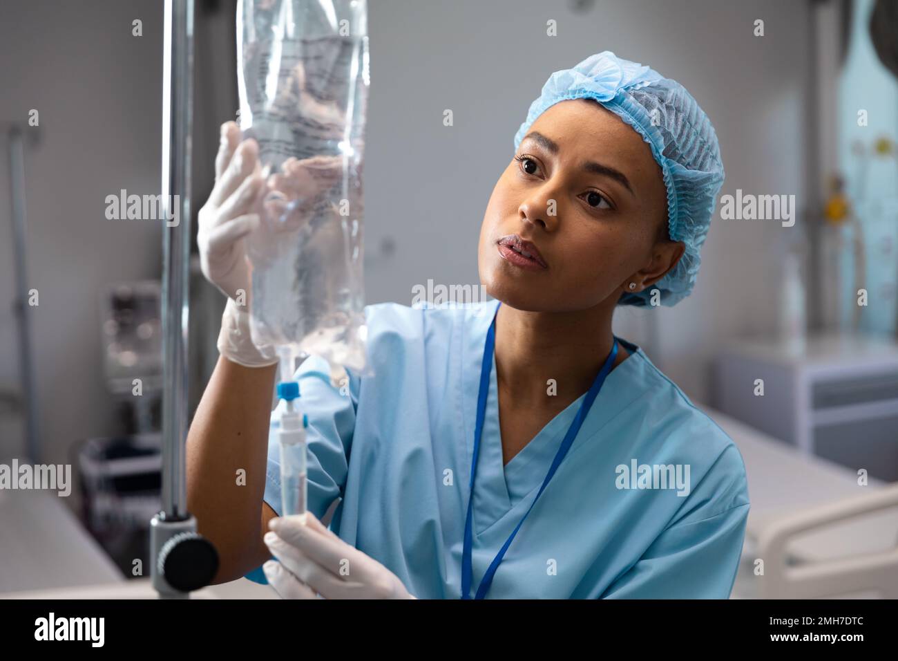 Dottore afro-americano che lavora in ospedale, cambiando fleboclisi Foto Stock