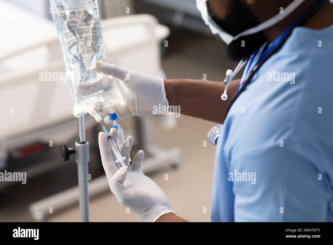 Medico afro-americano che lavora in ospedale, cambiando gocciolamento Foto Stock