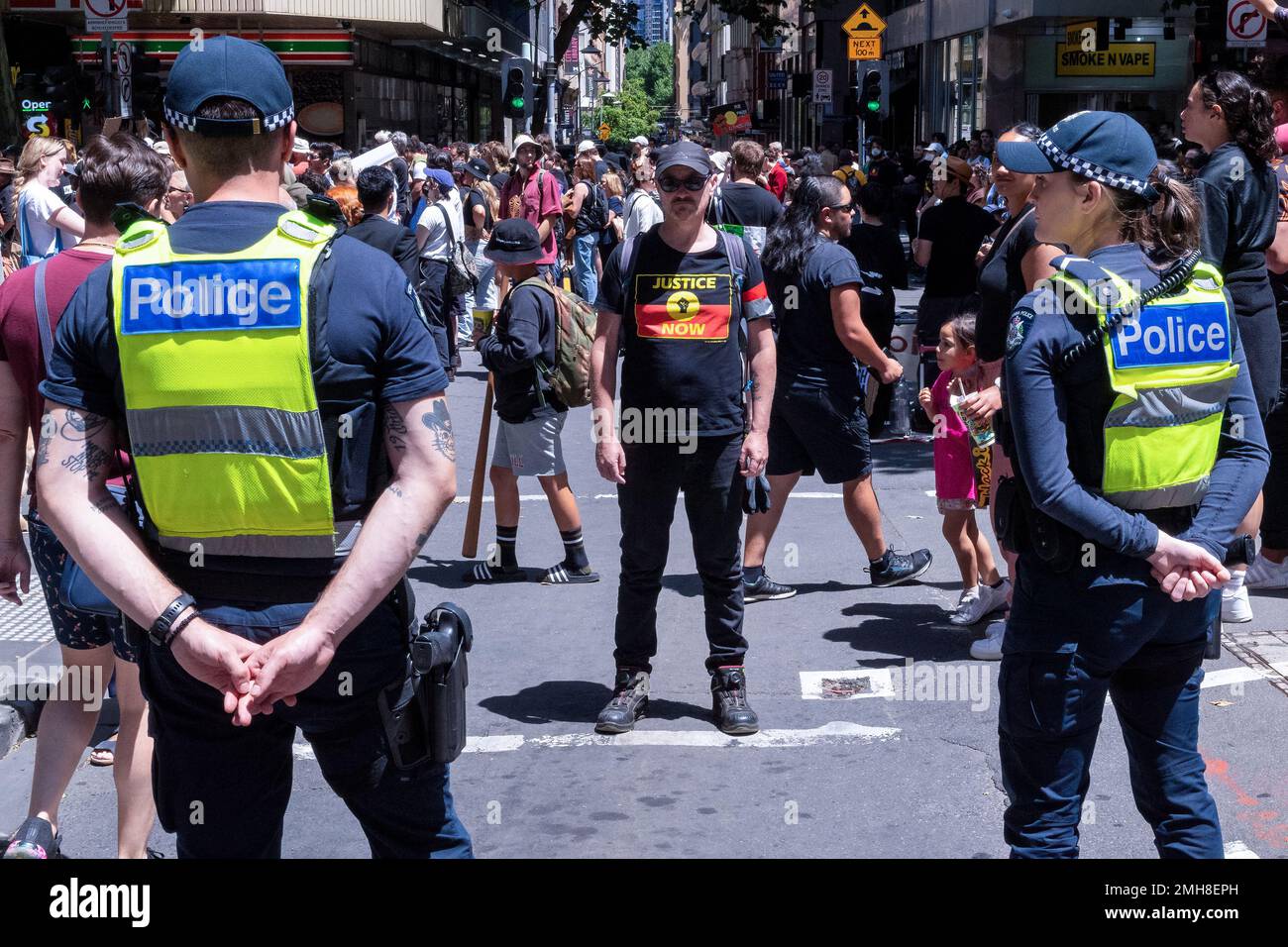 Melbourne, Australia, 26 gennaio 2023. Un manifestante tiene sotto controllo gli ufficiali di polizia durante la protesta annuale della Giornata dell'invasione a Melbourne, organizzata dagli australiani indigeni e dai loro alleati, chiede la fine della celebrazione della Giornata dell'Australia e il riconoscimento della sovranità indigena. Credit: Michael Currie/Speed Media/Alamy Live News Foto Stock