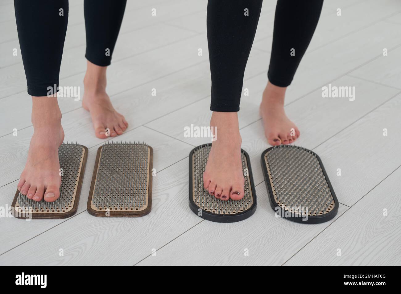 Primo piano dei piedi di due donne sulle unghie di sadhu. Vista dall'alto. Foto Stock