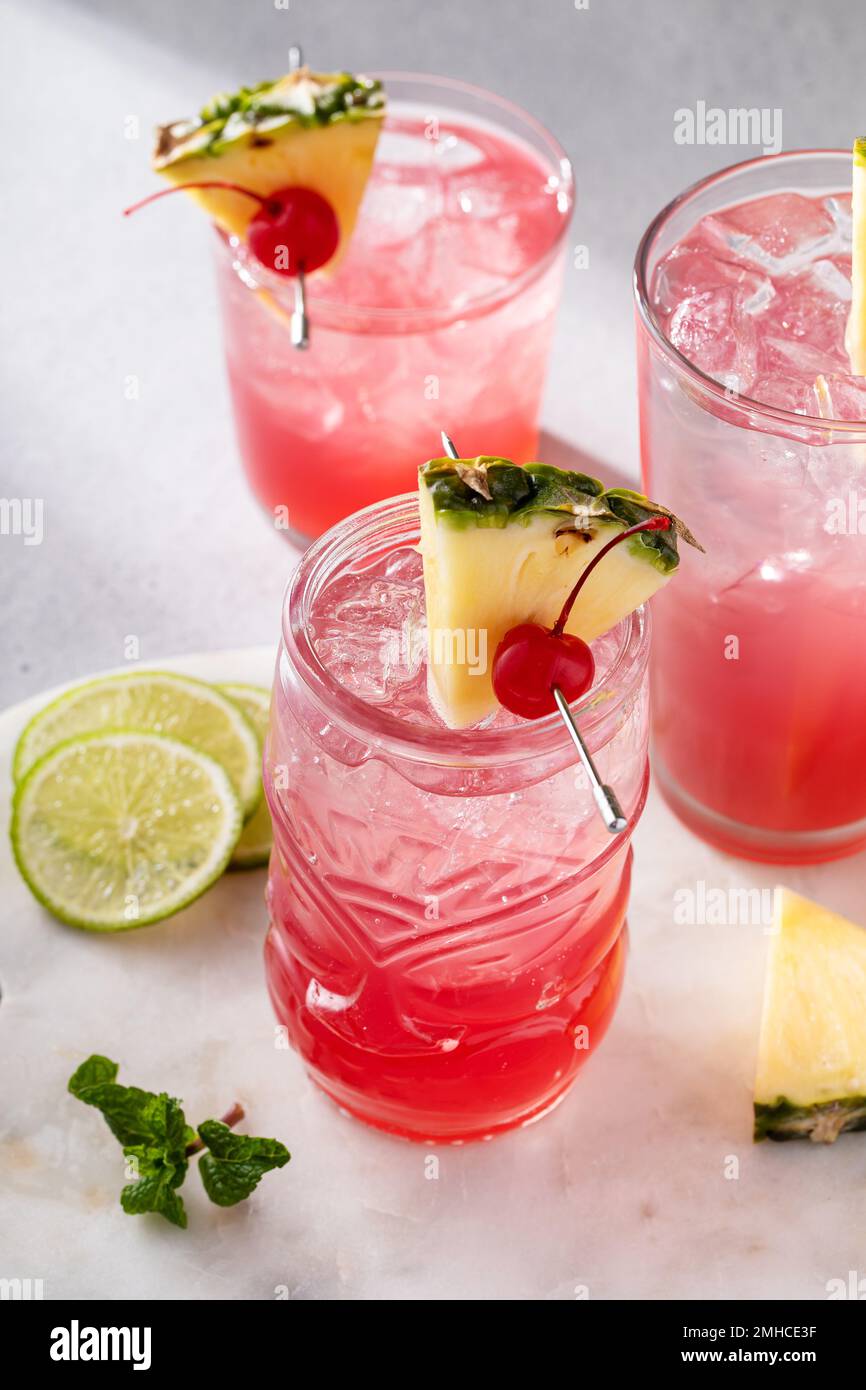 Singapore sling cocktail in una varietà di bicchieri Foto Stock