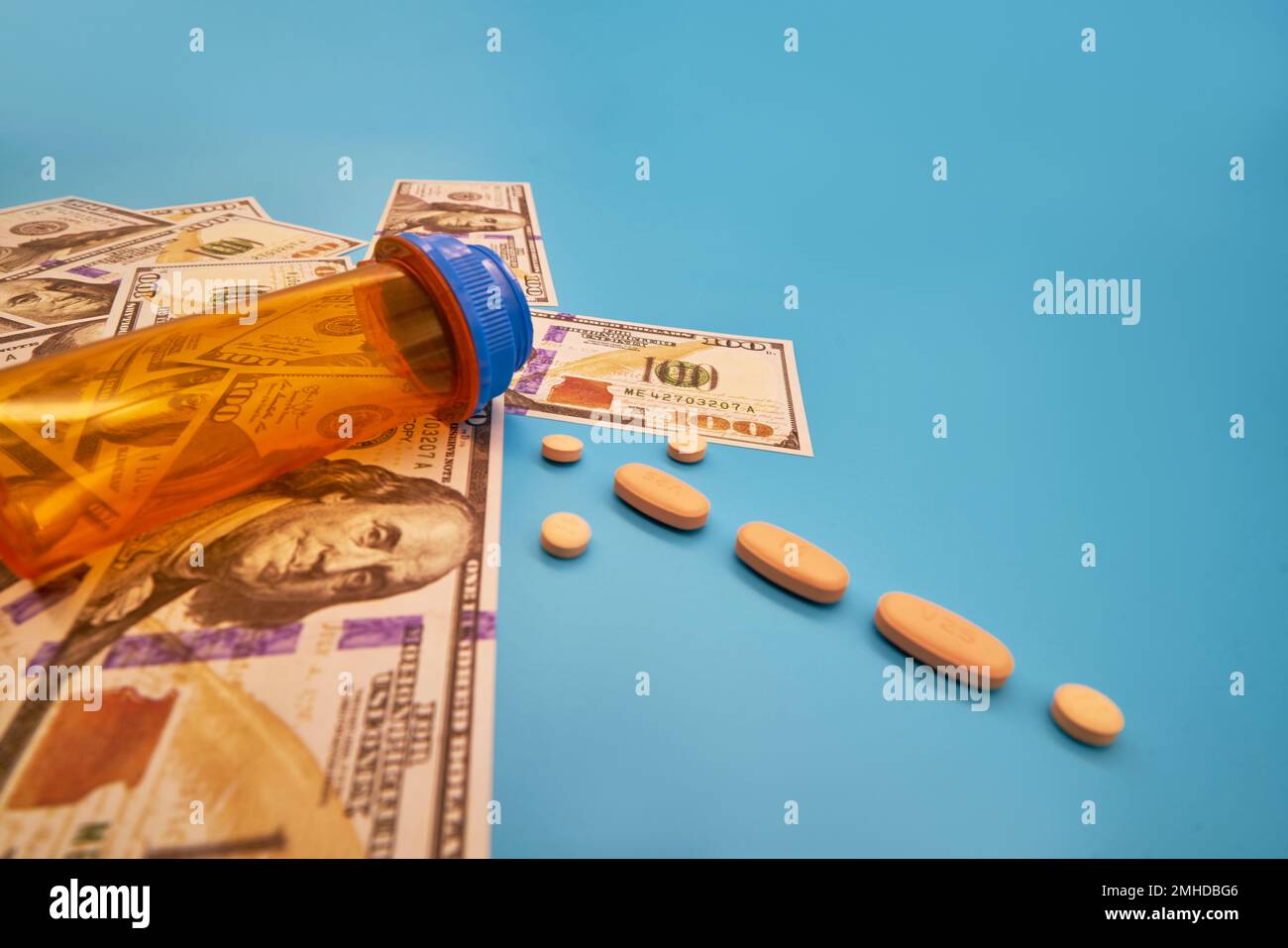 Crisi oppiacea farmaci pillole prescrizione farmaci e denaro blu chiaro sfondo flacone di medicina centinaia di dollari Foto Stock