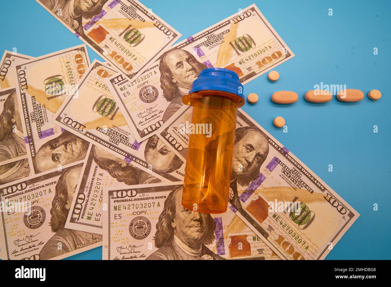 Crisi oppiacea farmaci pillole prescrizione farmaci e denaro blu chiaro sfondo flacone di medicina centinaia di dollari Foto Stock