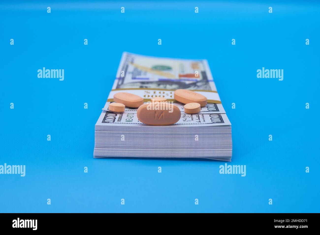 Crisi oppiacea farmaci pillole prescrizione farmaci e denaro sfondo azzurro centinaia di dollari Foto Stock