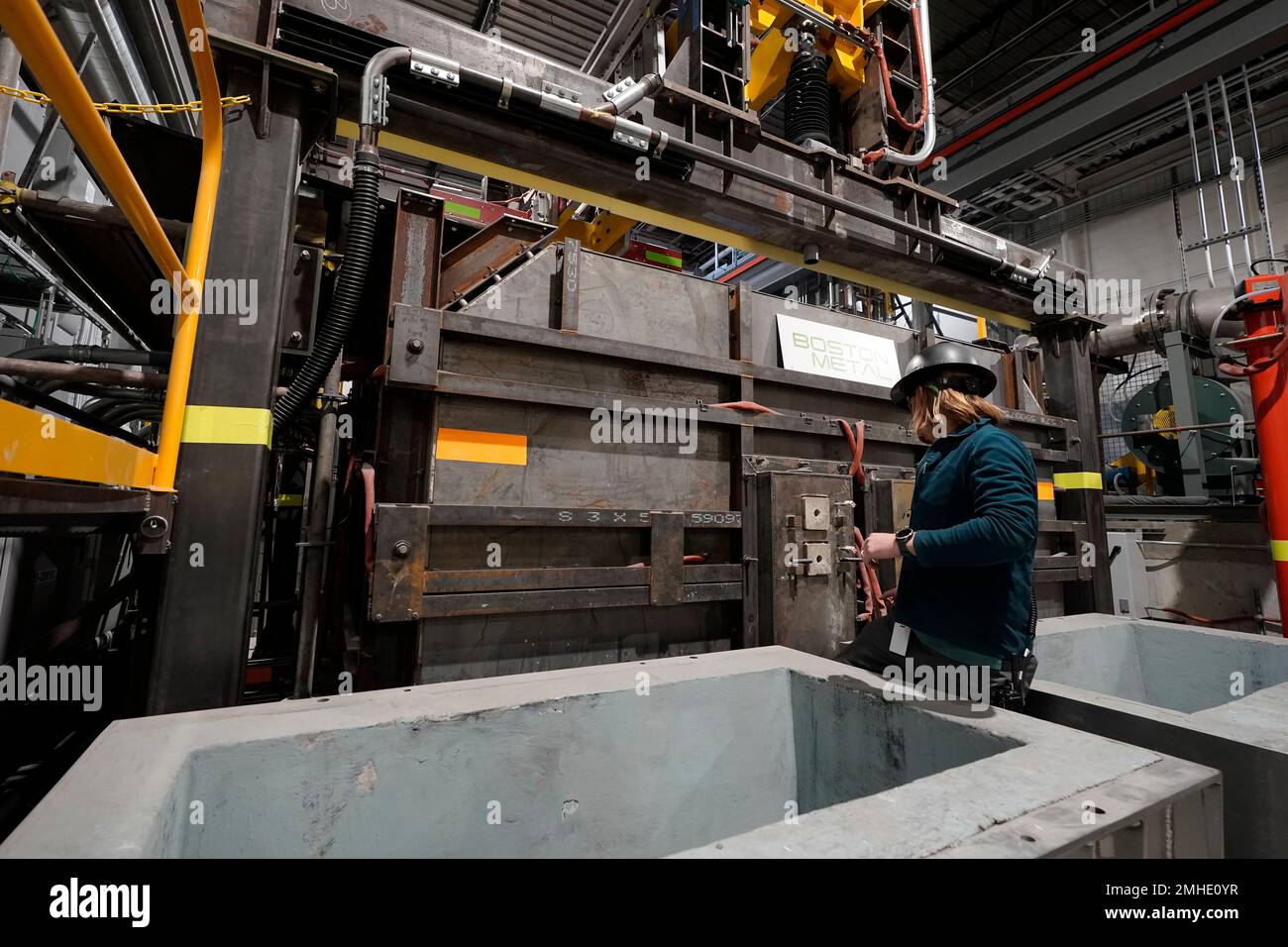 A worker makes an adjustment to a semiindustrial electrolytic cell