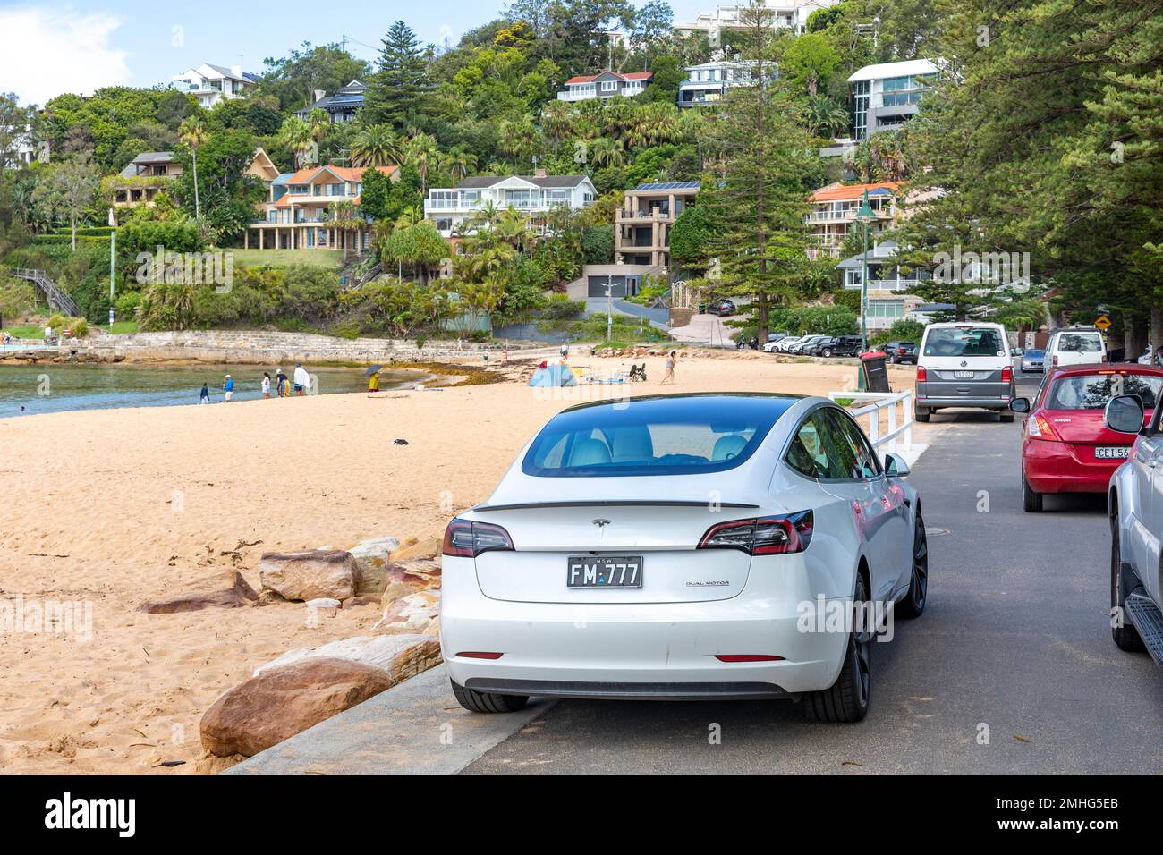 Auto elettrica Tesla modello 3 bianca, modello anno 2020, parcheggiata a Palm Beach a Sydney in un giorno estivo, Sydney, NSW, Australia Foto Stock