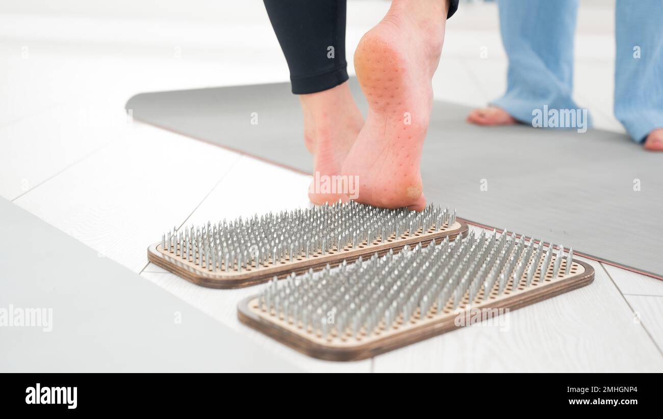 Una donna scende dalle tavole di sadhu. Primo piano dei piedi con stampe dopo le unghie. Foto Stock