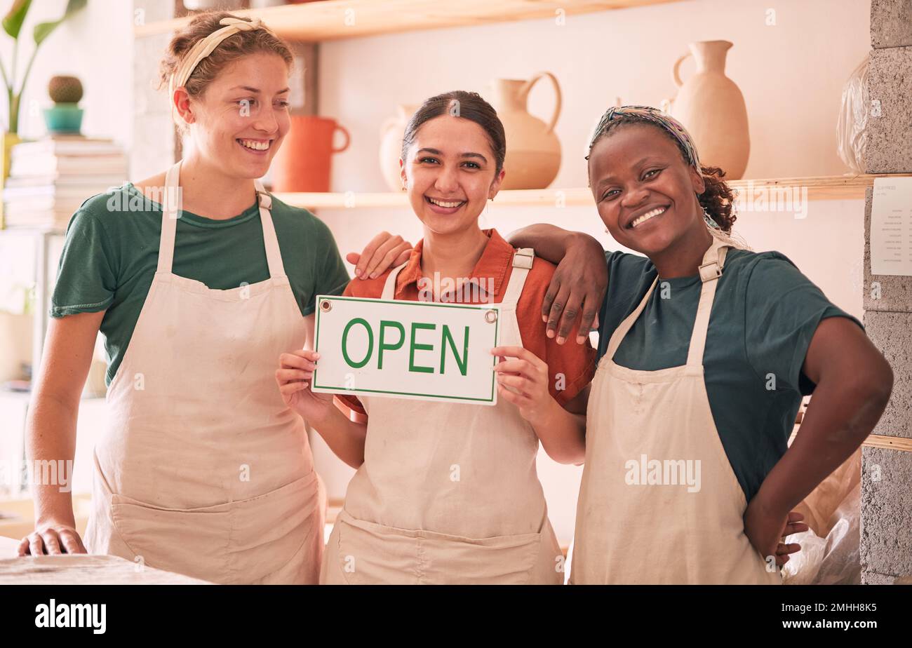 Piccole imprese, partnership e donne con segno aperto per la ceramica startup, laboratorio creativo e studio d'arte. Sorriso, lavoro di squadra e proprietari felici per Foto Stock