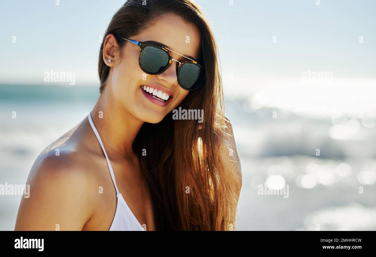 Gli occhiali da sole sono piccoli pezzi d'arte Primo piano di una bella giovane donna che trascorre un po' di tempo in spiaggia. Foto Stock
