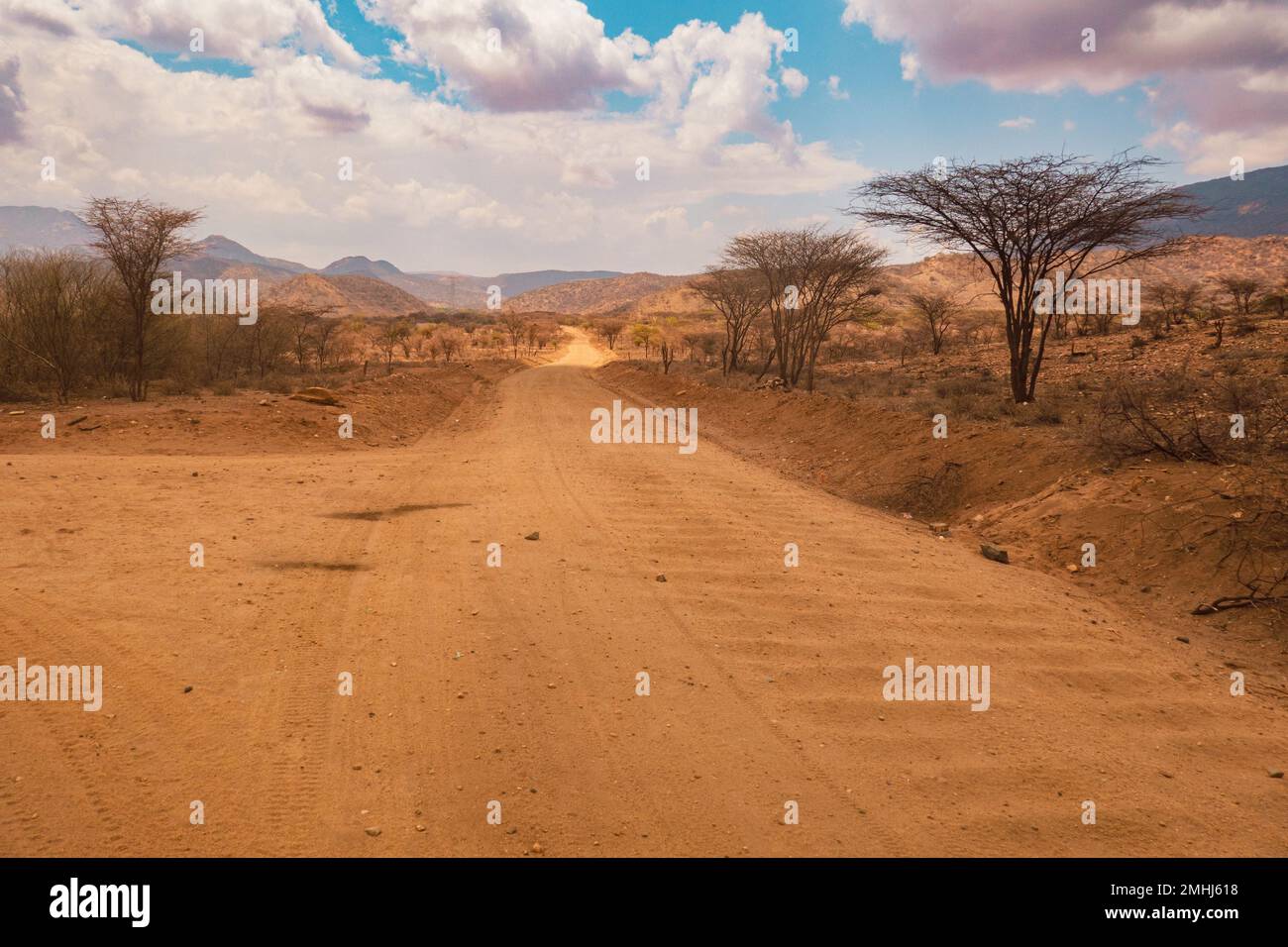 Una strada sterrata sullo sfondo delle montagne di Ndato in Kenya Foto Stock