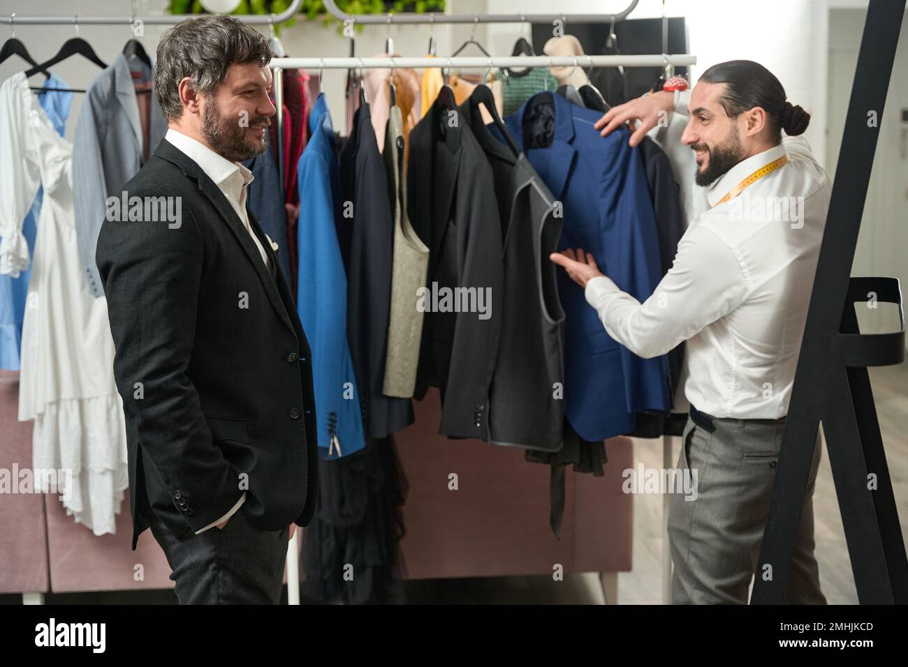 Cliente soddisfatto che ha ammirato la sua tuta personalizzata in studio su misura Foto Stock