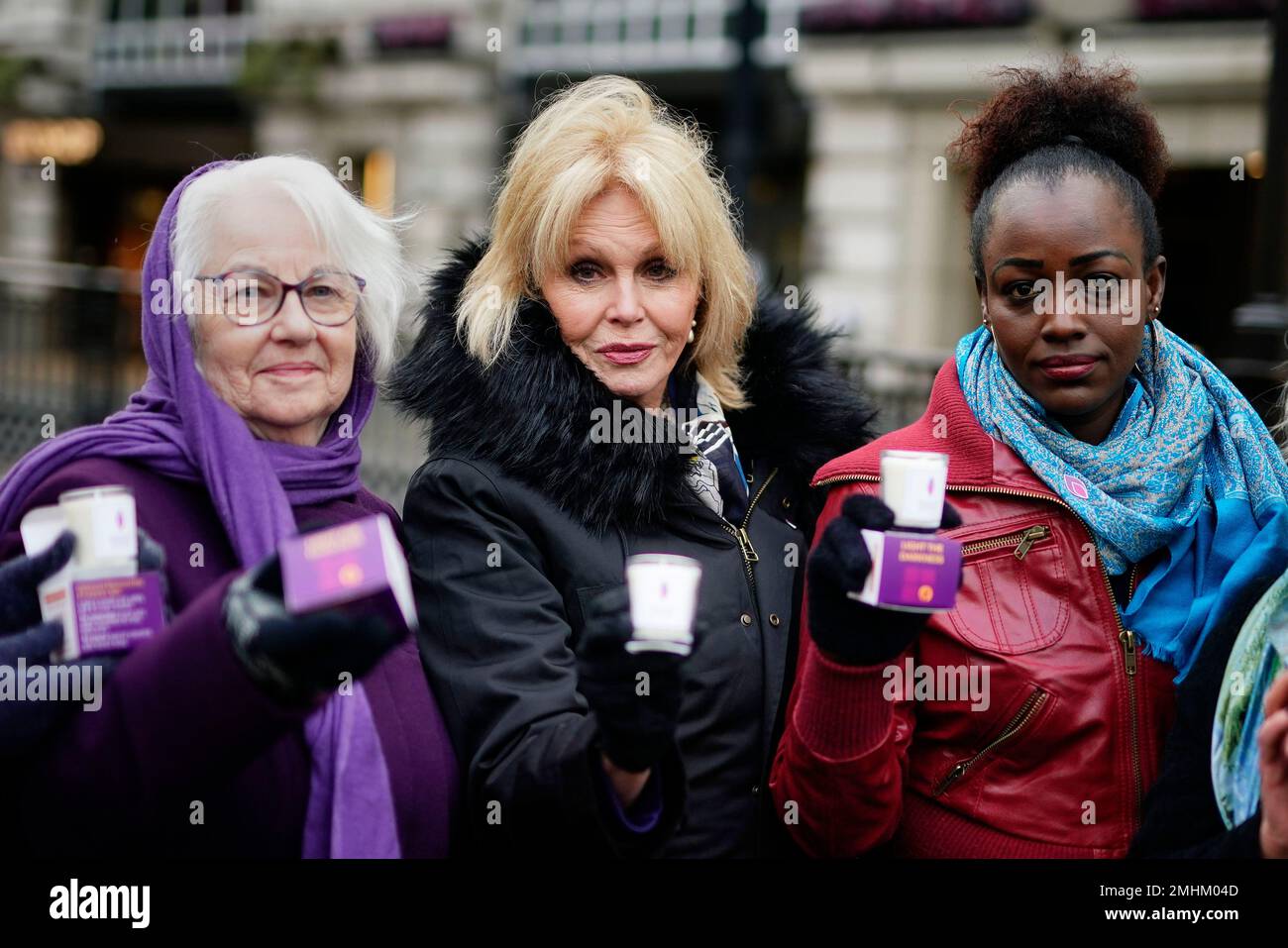 Dame Joanna Lumley (al centro) consegna candele commemorative a Piccadilly Circus, nel centro di Londra, accanto al sopravvissuto all'Olocausto Joan Salter (a sinistra) e al sopravvissuto al genocidio ruandese Antoinette Mutabazi (a destra), per celebrare il Memorial Day dell'Olocausto. Data immagine: Venerdì 27 gennaio 2023. Foto Stock
