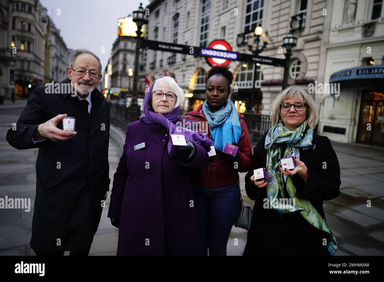 I sopravvissuti all'Olocausto e i successivi genocidi distribuiscono candele commemorative a Piccadilly Circus, nel centro di Londra, per celebrare il Memorial Day dell'Olocausto. Data immagine: Venerdì 27 gennaio 2023. Foto Stock