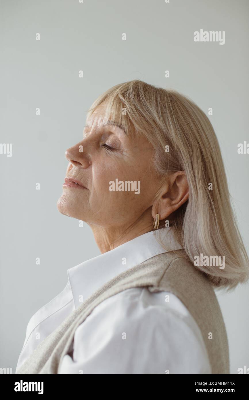 Studio ritratto di una donna anziana dai capelli grigi da sogno. Foto Stock