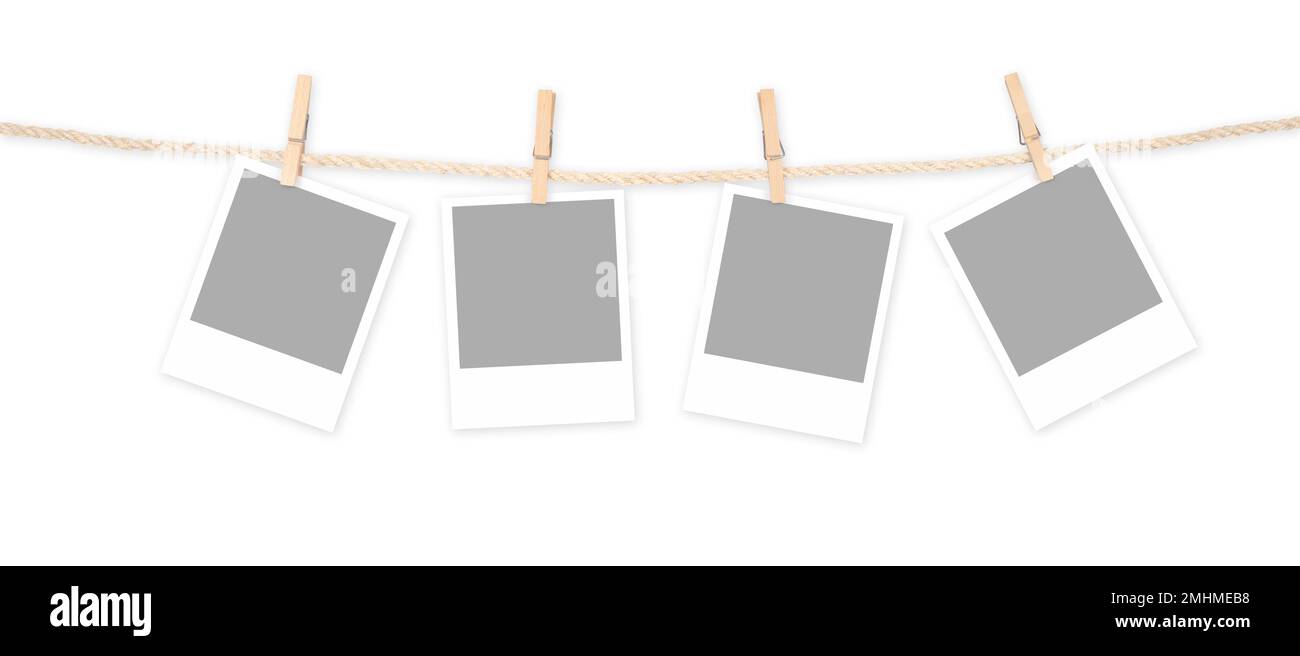 Quattro telai polaroidi vuoti e clothespins attaccati ad una corda isolata su sfondo bianco. Tracciato di ritaglio incluso. Foto Stock