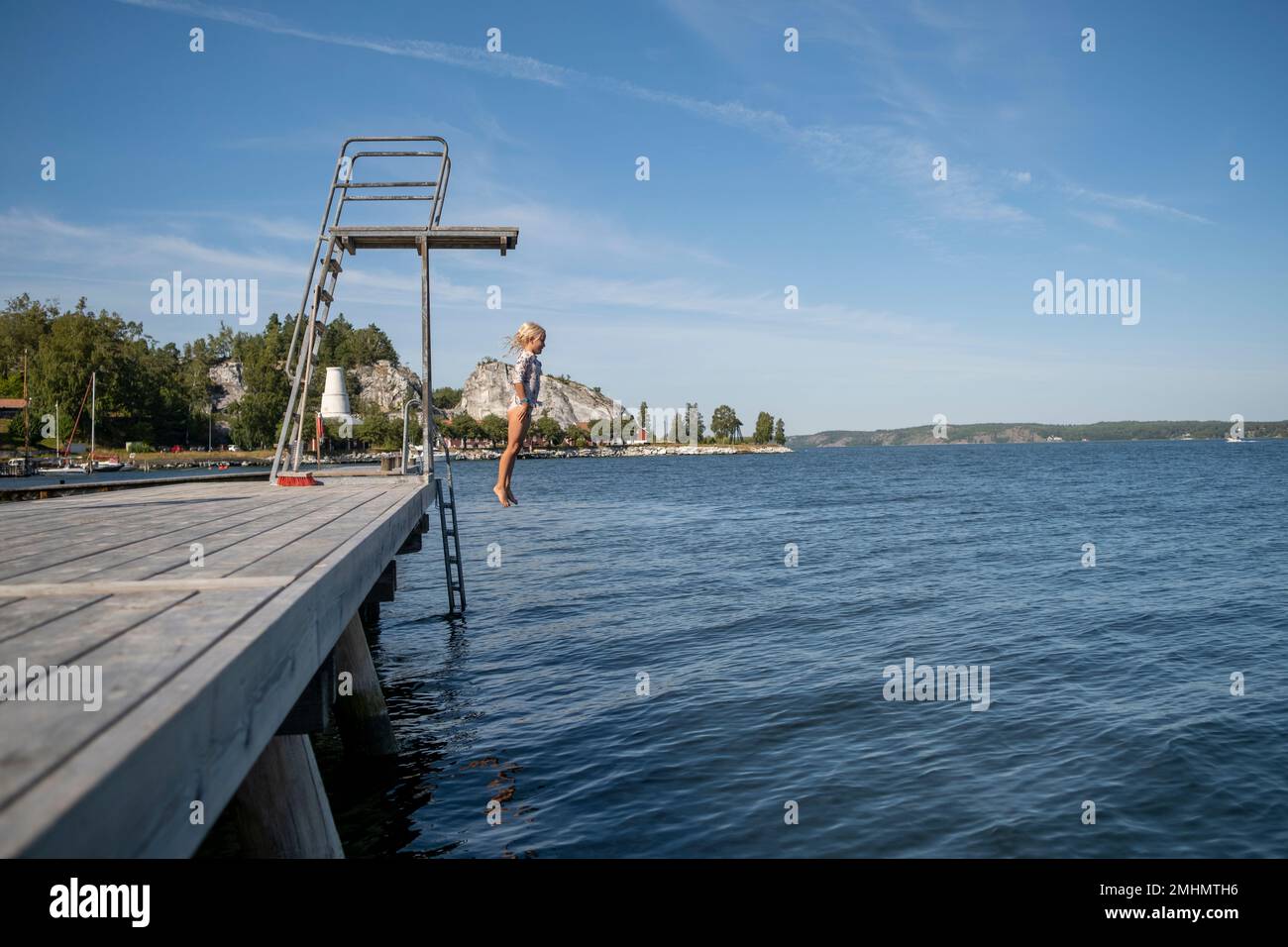 Ragazza che salta dalla torre di immersione Foto Stock