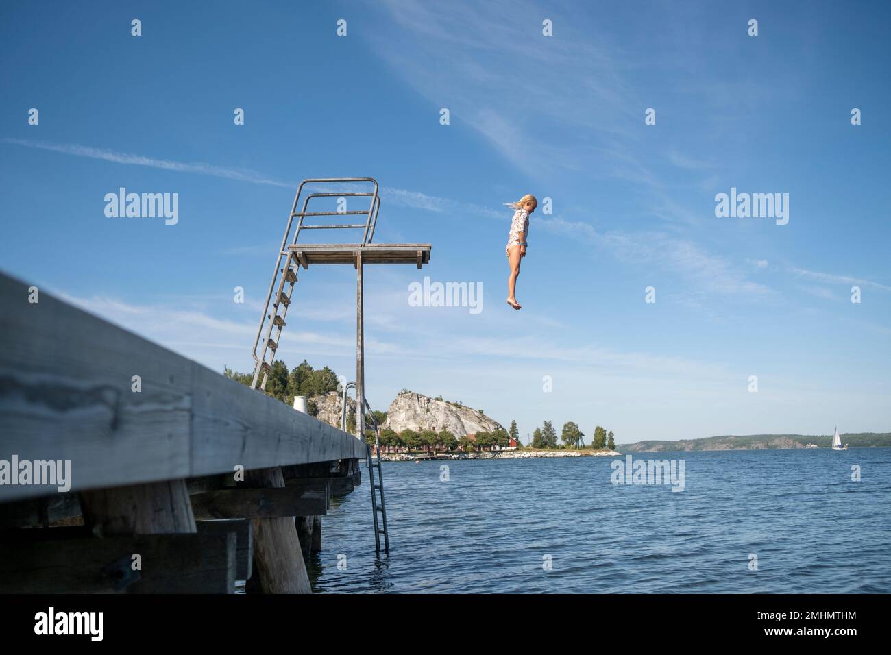 Ragazza che salta dalla torre di immersione Foto Stock