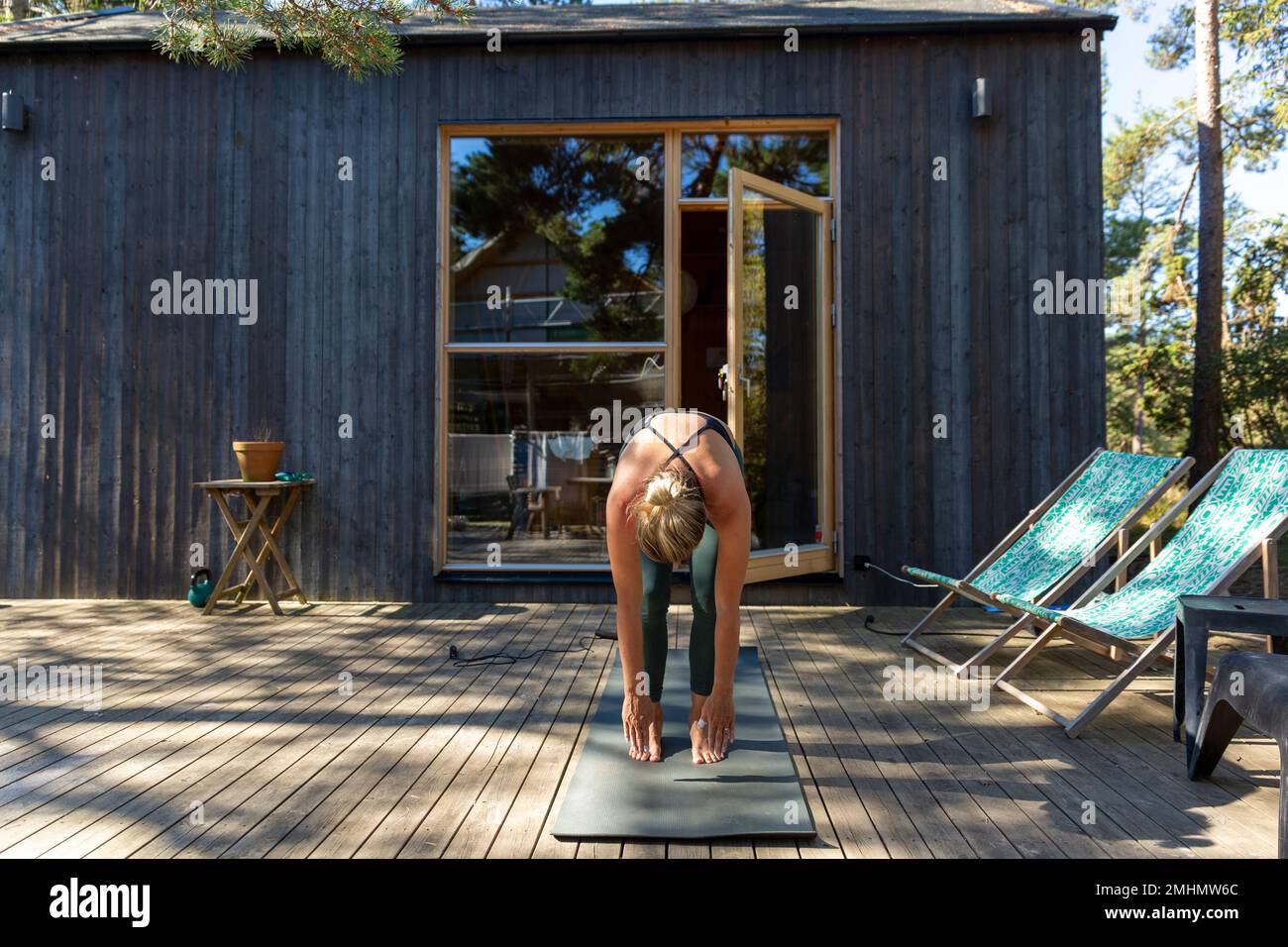 La donna a praticare yoga sul patio Foto Stock