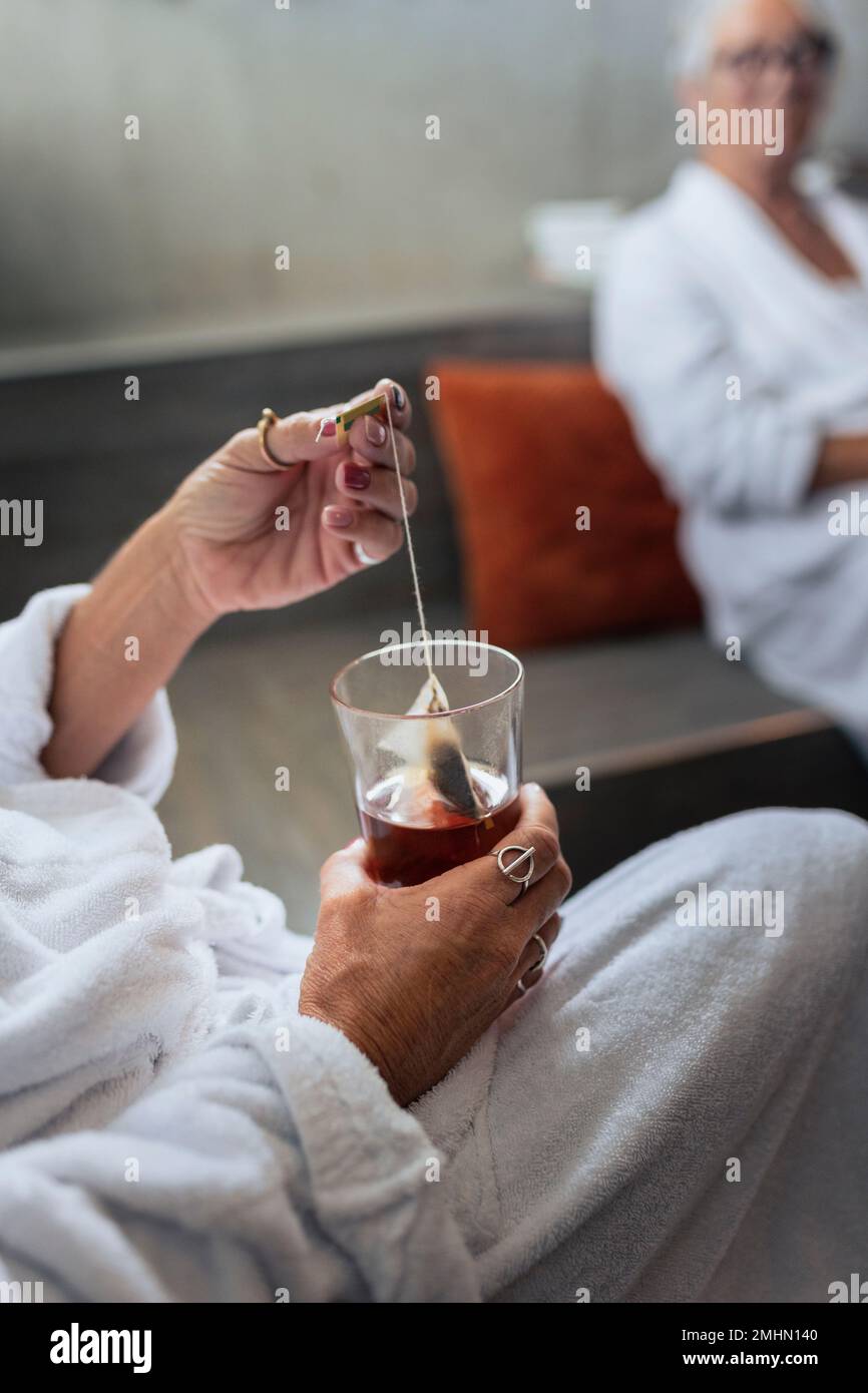 Mano della donna che tiene il teabag Foto Stock