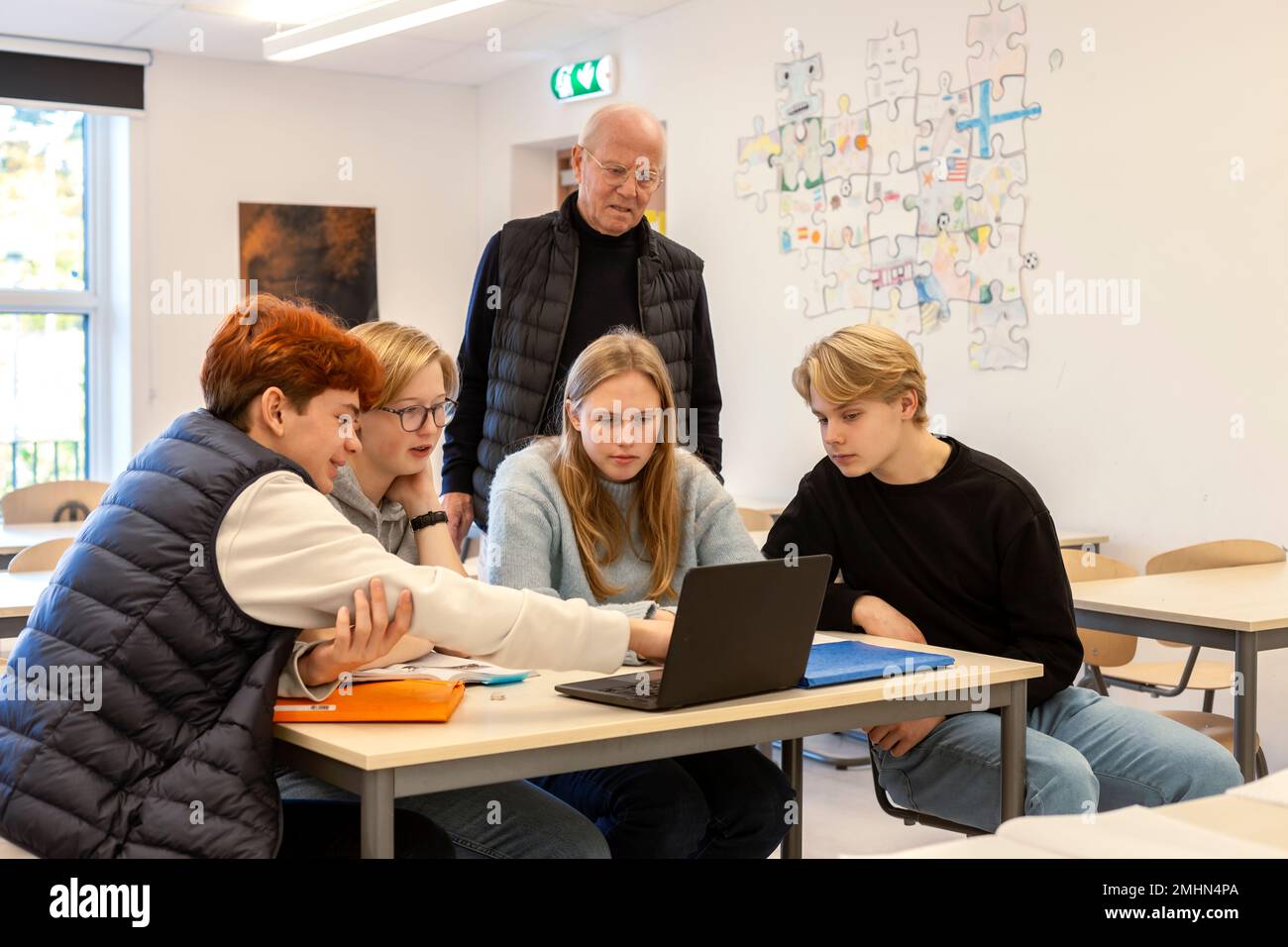 Ragazzi adolescenti e insegnanti che utilizzano il computer portatile in classe Foto Stock
