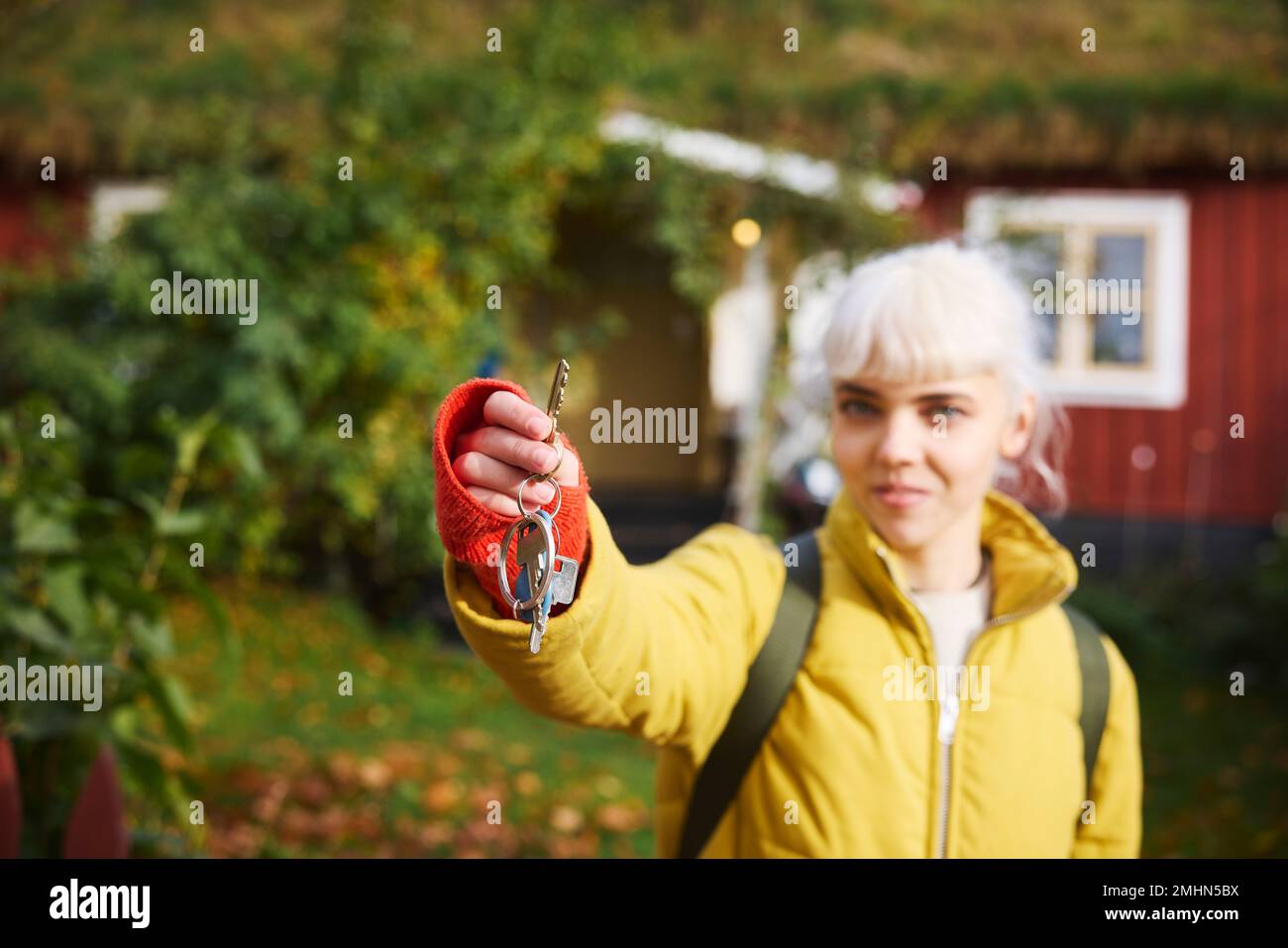 Donna sorridente che tiene le chiavi della casa Foto Stock