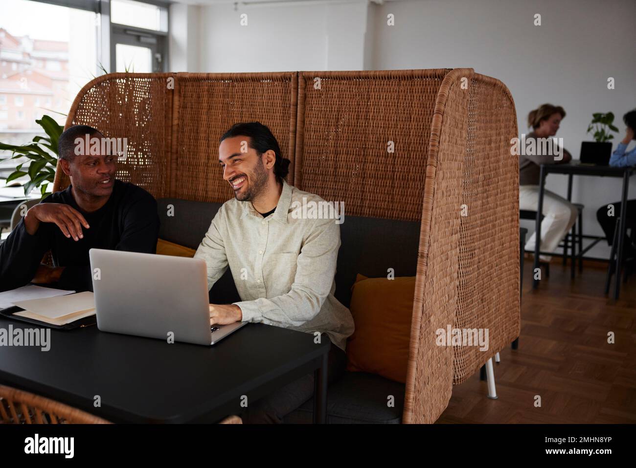 Uomini che usano il computer portatile in caffetteria Foto Stock