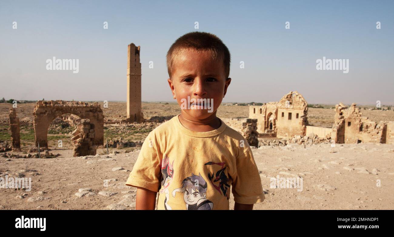 Ritratto di un bambino di 6 anni di età locale che si trova di fronte all'antica città di Harran, Harran, Urfa, Turchia Foto Stock
